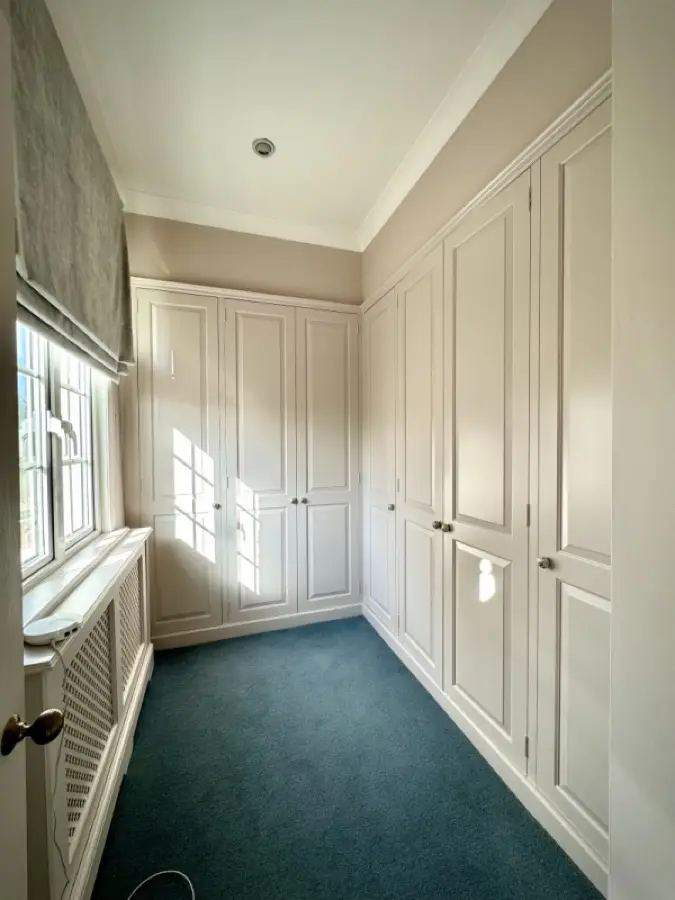 Fitted wardrobes in a bedroom, repainted in soft white