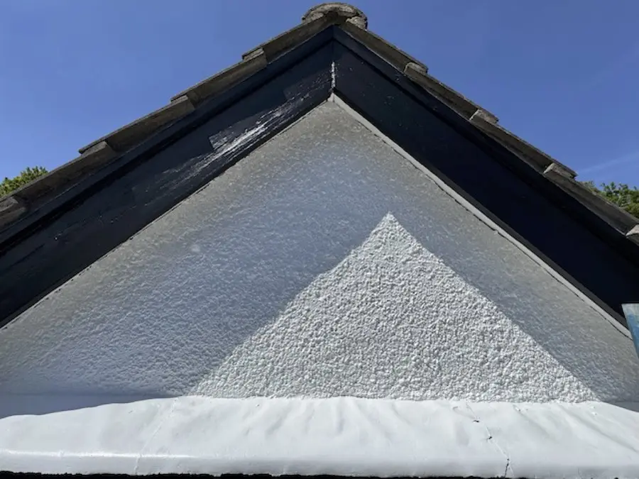 Victorian gable after restoration: smooth white render with black fascia boards