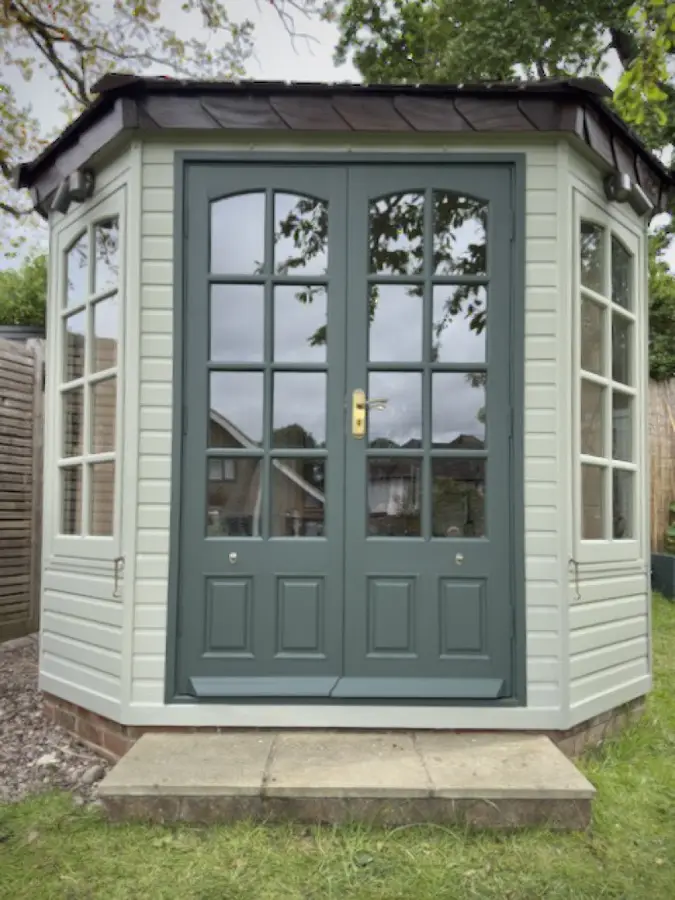 Octagonal garden office with doors and frames repainted in sage green